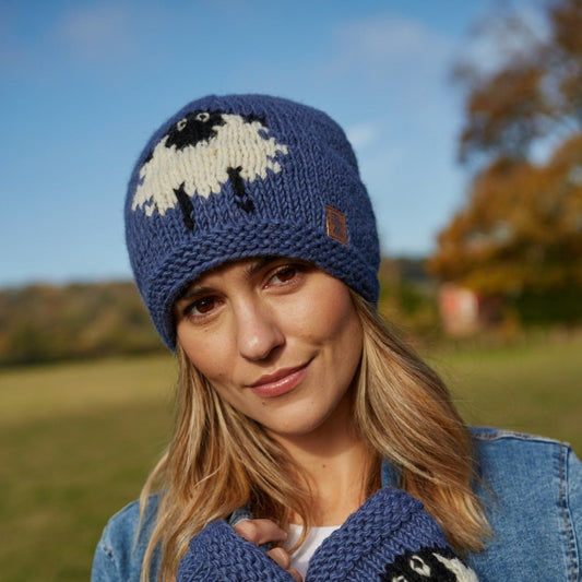 Lady wearing a flattering blue beanie hat with a large sheep to the front